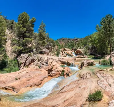 a river in a canyon with rocks and trees at Doce de Colón C in Requena