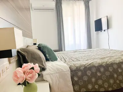 a bedroom with a bed and a flower in a vase at Casa Burriana con sauna in Burriana
