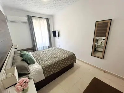 a bedroom with a bed and a mirror at Casa Burriana con sauna in Burriana