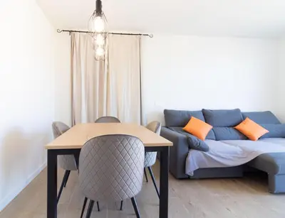 a living room with a couch and a table at Global Vacacional, Apartamento con piscina en Puerto de Sagunto in Puerto de Sagunto