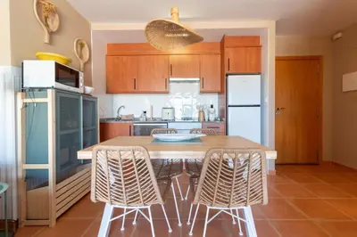 a kitchen with a table with chairs and a refrigerator at Global Vacacional, Planta baja con piscina en Almenara in Almenara