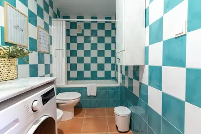 a bathroom with blue and white tiled walls and a toilet at Global Vacacional, Planta baja con piscina en Almenara in Almenara