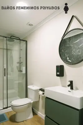 a bathroom with a toilet and a sink and a mirror at U-nit Hostel Central Park in Valencia