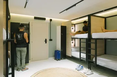 a man standing in a room with bunk beds at U-nit Hostel Central Park in Valencia