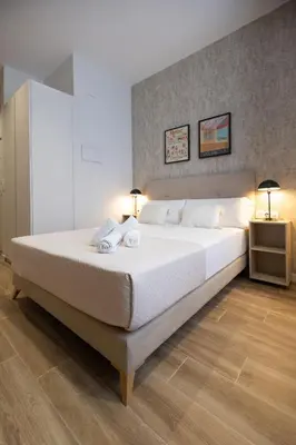 a bedroom with a large bed with two towels on it at Rubio Rooms by Concept in Valencia