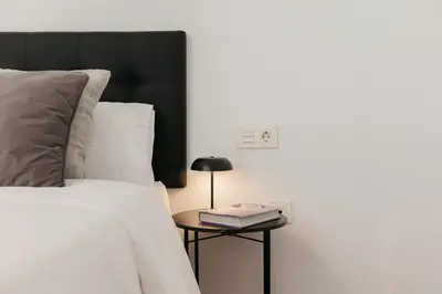 a bedroom with a bed and a side table with a lamp at Premium, Lux & Comfort by the Sea in Valencia