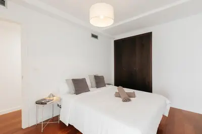 a bedroom with a large white bed and a table at Premium, Lux & Comfort by the Sea in Valencia