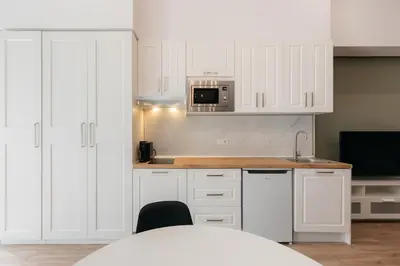 a kitchen with white cabinets and a microwave at New! Comfort and Style Steps from Everything in Valencia