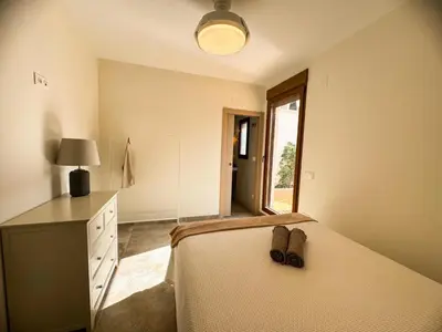 a bedroom with a bed and a dresser and a window at Piscina & Espacio & Confort entre Playa y Montaña in San Antonio de Banageber