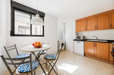 a kitchen with a table and chairs in a kitchen at Urban Oasis near the beach in Puerto de Sagunto