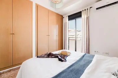 a bedroom with a bed with a hat and a window at Urban Oasis near the beach in Puerto de Sagunto