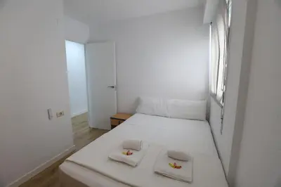 a small bedroom with a white bed with two towels on it at Panoramic Mediterranean Views Beachfront in Puerto de Sagunto