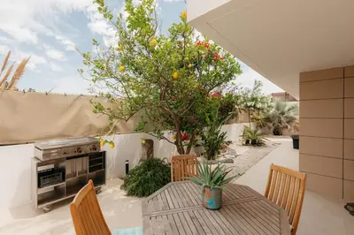 a patio with a table and chairs and a tree at Grand Villa with Pool in Sagunto