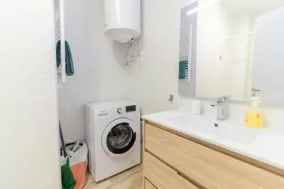 a white bathroom with a washing machine and a sink at Super Apto 2habitaciones dobles 4 pax wifi terraza in Valencia