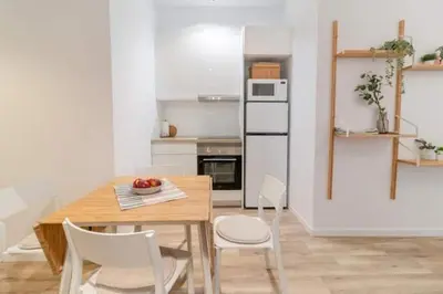 a kitchen with a wooden table and white chairs at Super Apto 2habitaciones dobles 4 pax wifi terraza in Valencia