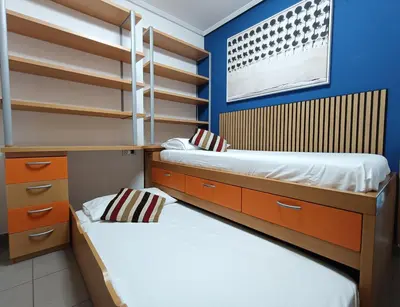 two beds in a room with blue walls and shelves at Valencia Playa Patacona Resort in Valencia