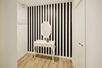 a white dressing table with a mirror on a striped wall at Serrano flat in Valencia