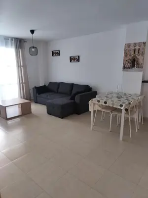a living room with a couch and a table at Apartamento en playa de Moncofar con wifi y aire acondicionado in Moncófar