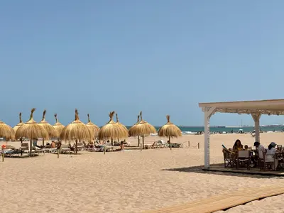 a beach with umbrellas and people sitting on the sand at Valencia Beach Home 8 in Valencia
