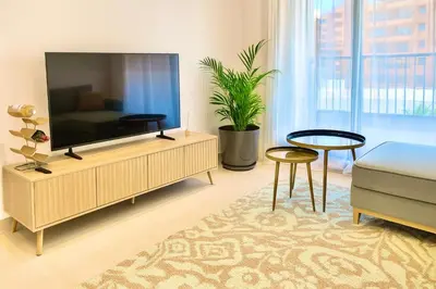 a living room with a flat screen tv and a table at Valencia Beach Home 8 in Valencia