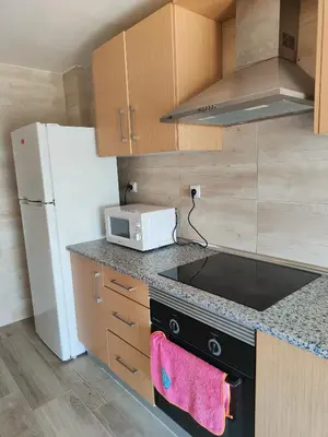 a kitchen with a stove and a white refrigerator at Avenida Mediterráneo in Puerto de Sagunto