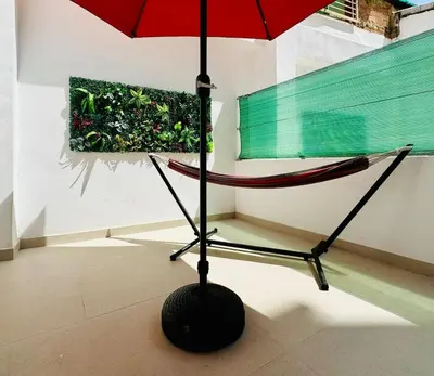 a hammock with a red umbrella in a room at PLANAS 2 Design & Spaciousness with Terraza in Ruzafa SOHO in Valencia