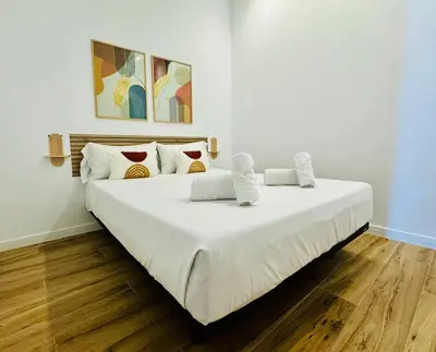 a large white bed in a room with wooden floors at PLANAS 2 Design & Spaciousness with Terraza in Ruzafa SOHO in Valencia