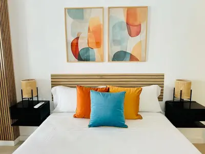 a bed with orange and blue pillows in a room at PLANAS 3 Designer Aparment with Terraza in Ruzafa SOHO in Valencia