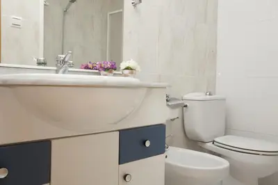 a white bathroom with a sink and a toilet at Apartments Serrería II in Valencia