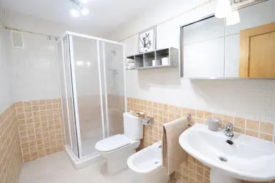 a bathroom with a toilet and a sink and a shower at Dúplex tranquilo frente al mar en Xilxes Terraza, parking y WiFi in Chilches