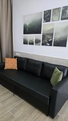 a black leather couch in a room with pictures on the wall at Apartamentos Vicent Clavel in Valencia