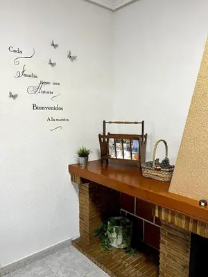 a room with a fireplace with a sign on the wall at Casa el Catorce 18 in Bolbaite