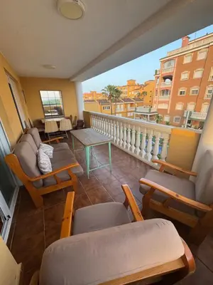 a balcony with furniture and a view of a city at Gaviota Azul, Perelló in Sueca