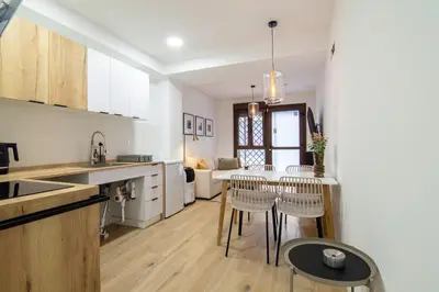 a kitchen and living room with a table and chairs at Casa Sant Domènec Savio in Valencia