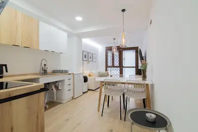a kitchen and living room with a table and chairs at Casa Sant Domènec Savio in Valencia