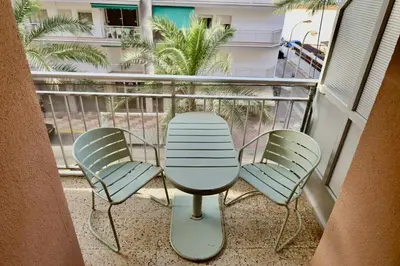 a balcony with three chairs and a table on it at Cozy Seaside Apartment in Cullera in Cullera