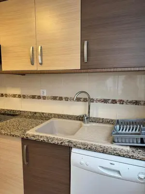 a kitchen with a sink and wooden cabinets at Sweet Stay Valencia in Valencia