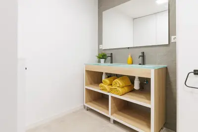 a bathroom with a sink and yellow towels at Urban apartment BAJO 6 - HOUSEVANLIVE in Valencia
