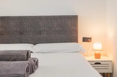 a bedroom with two beds with a headboard and a lamp at Suite Deluxe Valencia - Beach Apartments I in Valencia