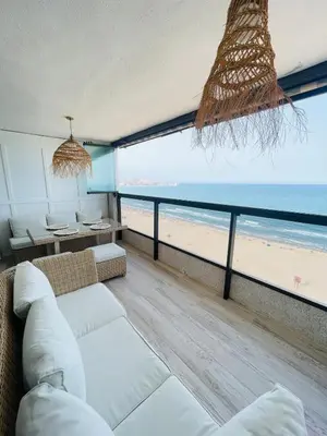 a living room with a couch and a view of the beach at Sobre el mar in Cullera