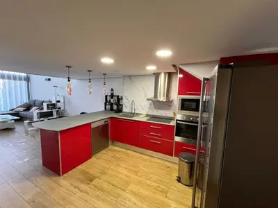 a kitchen with red cabinets and a counter top at Loft con jacuzzi y piscina in Valencia