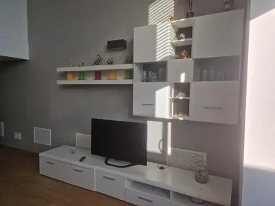 a living room with a television on a white cabinet at Loft con jacuzzi y piscina in Valencia
