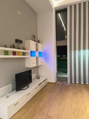 a living room with a television on a white cabinet at Loft con jacuzzi y piscina in Valencia