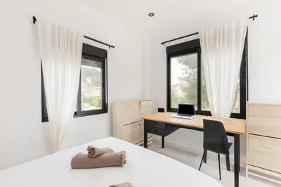 a bedroom with a desk with a laptop on it at Spacious villa with private pool & garden for 4 in Partida de La Cañada
