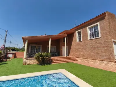 a house with a swimming pool in front of it at Villa Pepita in Torrent