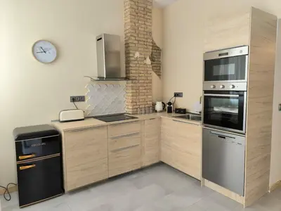 a kitchen with stainless steel appliances and a clock on the wall at Apartment next to the Marina De Valencia in Valencia