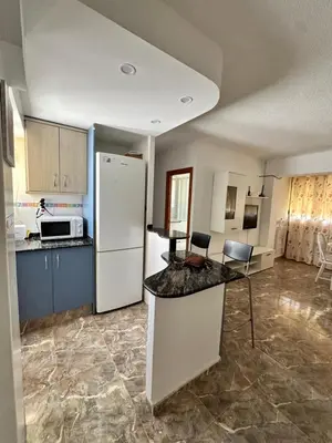a kitchen with a white refrigerator and a counter at Apartamento edificio JUMAR in Cullera