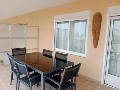 a dining room with a glass table and chairs at Nules Beach Apartment in Moncófar
