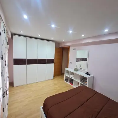 a bedroom with a bed and a dresser and a mirror at Nules Beach Apartment in Moncófar