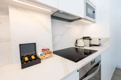a kitchen with a counter with a stove top oven at La Casa del Mar-Cabañal 3BR Suites in Valencia